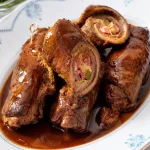 Traditionele Duitse runderrouladen op een bord met kruiden.