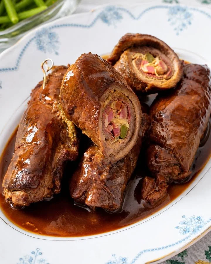 Traditionele Duitse runderrouladen op een bord met kruiden.