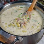 Een kom prei gehaktsoep met verse ingrediënten en kruiden.