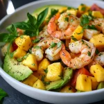 Avocado mango garnalen salade op een bord met een frisse presentatie