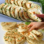 Knapperige knoflook flatbreads op een houten snijplank