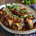 Pittige aubergine-rolletjes gevuld met rundvlees op een bord